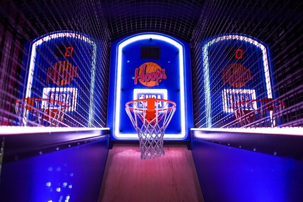 NBA logo behind a basketball hoop in a cage with a wooden floor