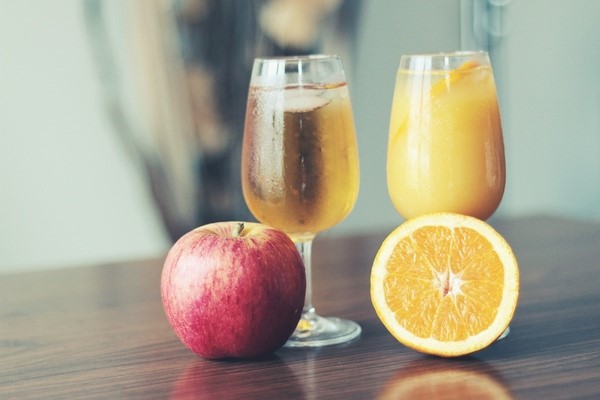 Apple and sliced orange next to champagne flutes