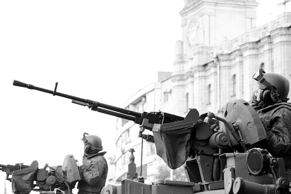 Grayscale photo of two men holding tank guns in the second world war